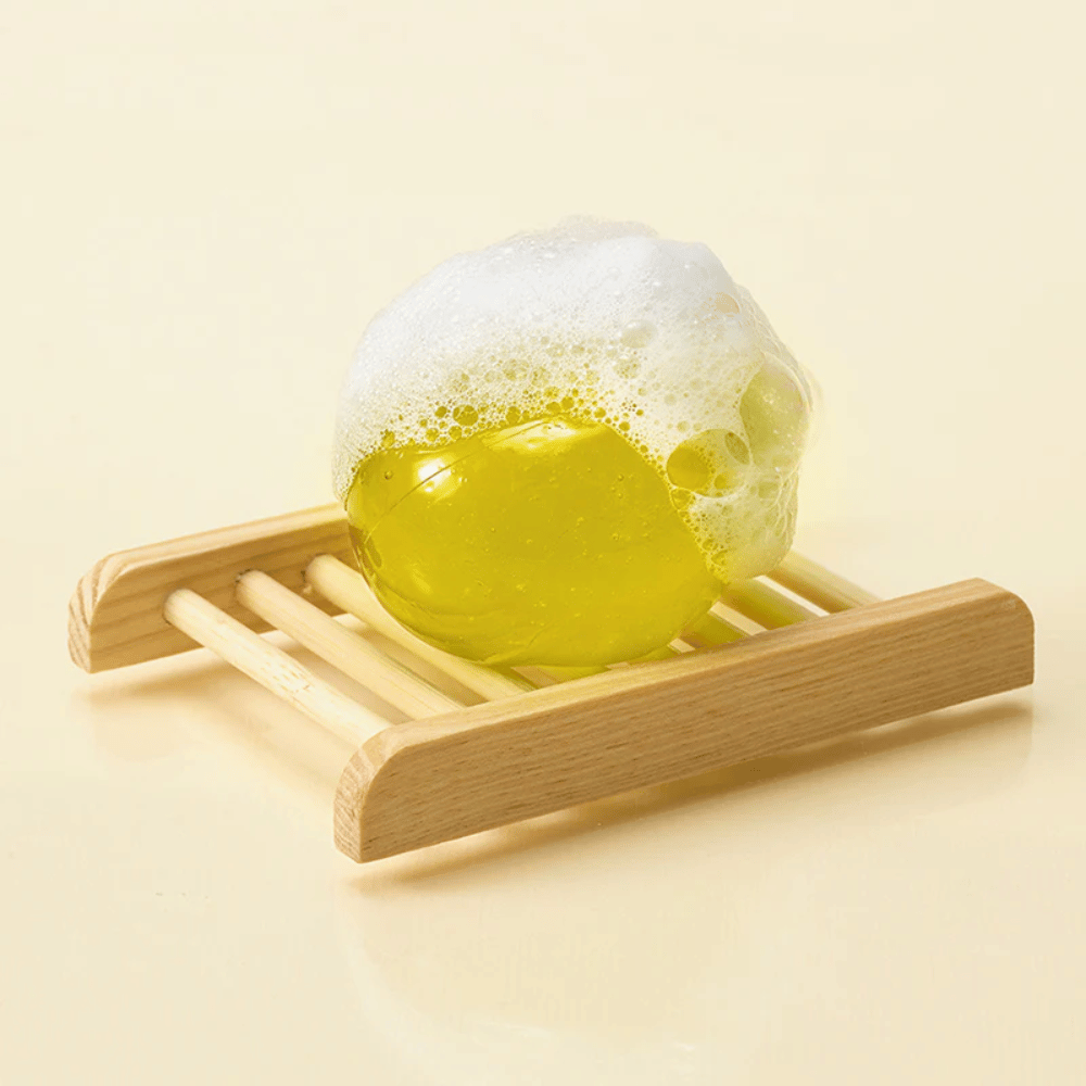 Schiumoso Ongredients Jeju Cica Cleansing Ball su piattino di sapone – detergente delicato che rafforza la barriera cutanea e riduce l'irritazione.