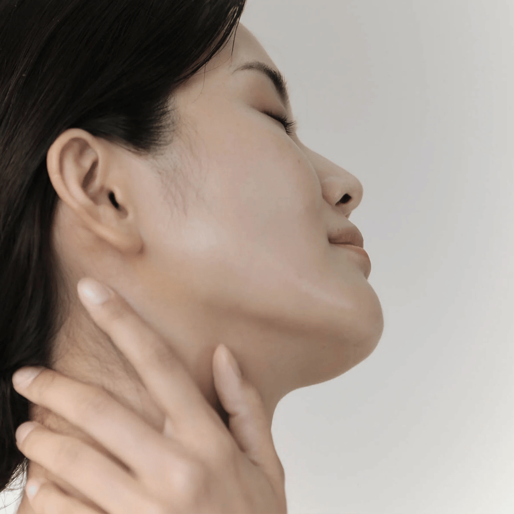 Una donna mostra la sua pelle calma e idratata dopo l'uso di Celimax Ji Woo Gae Cica BHA Blemish Toner Pad.