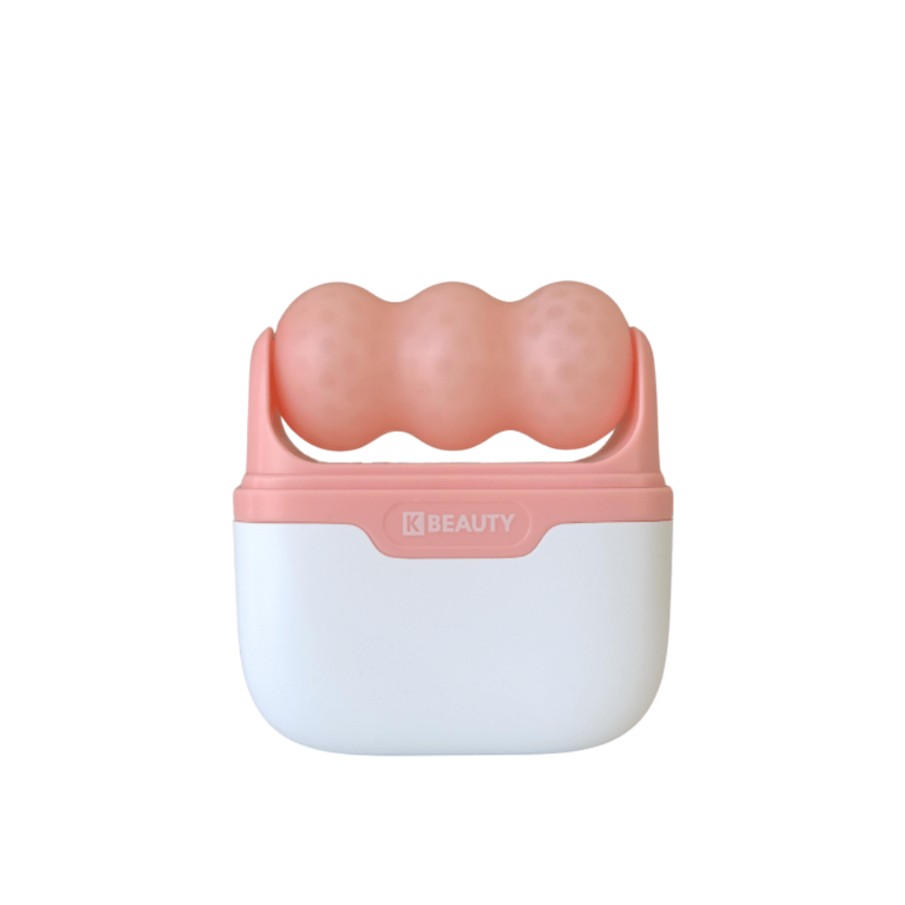 L'immagine mostra un K-Beauty Ice Roller con un manico bianco e rosa. Il prodotto ha tre rulli arrotondati e puntinati di colore rosa sulla parte superiore, progettati per raffreddare e massaggiare il viso. Lo sfondo è completamente bianco.