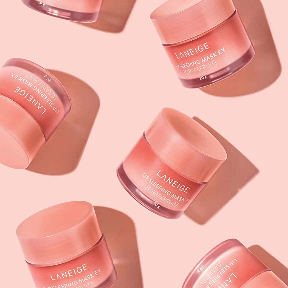 Quattro barattoli LANEIGE Lip Sleeping Mask Pompelmo 20g su sfondo rosa, promuove pompelmo e idratazione.