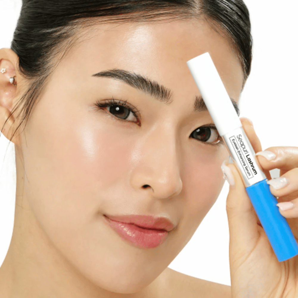 Donna tiene in mano Seapuri Lashrum Eyelash Enhancing Serum. Un siero per ciglia che rinforza e definisce le ciglia.