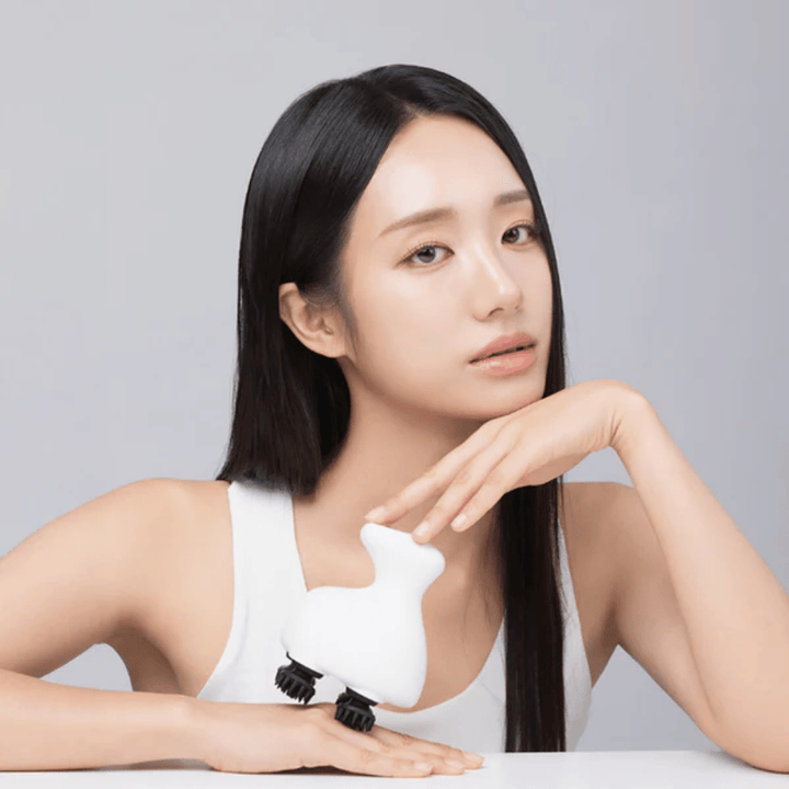 La modella posa con Beaund Lift Head Spa e mostra il design ergonomico. L'immagine mette in risalto il prodotto come uno strumento per il massaggio del cuoio capelluto e la cura di sé rilassante.