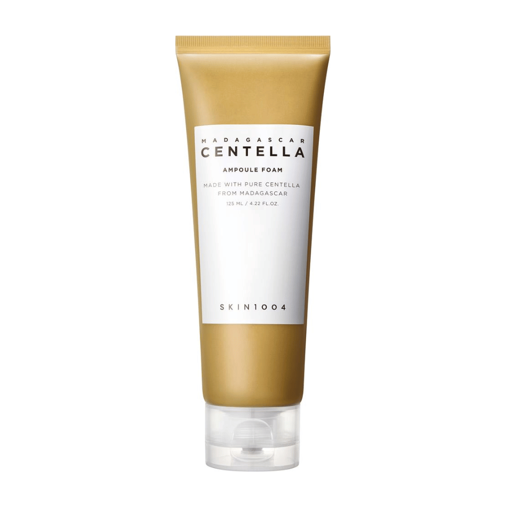 L'immagine mostra un tubo di "Madagascar Centella Ampoule Foam" del marchio SKIN1004. È un prodotto detergente per il viso che contiene 125 ml / 4.22 fl.oz. La formula è basata su pura Centella estratta da piante in Madagascar. Il prodotto è progettato per pulire delicatamente e curare la pelle.
