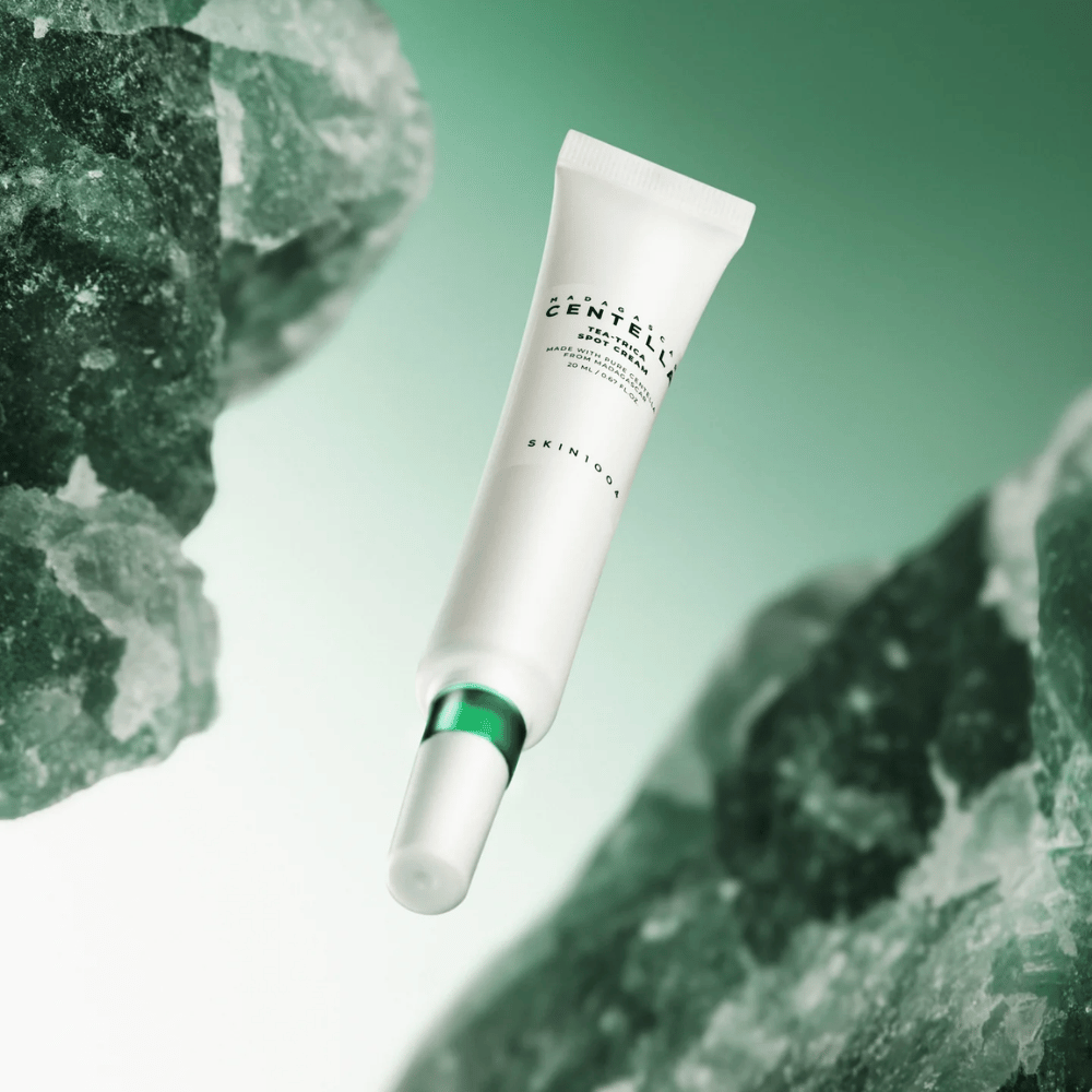 SKIN1004 Madagascar Centella Tea-Trica Spot Cream 20 ml contro acne e brufoli, immagine del prodotto con sfondo verde e struttura cristallina – trattamento puntuale calmante con centella asiatica e tea tree.