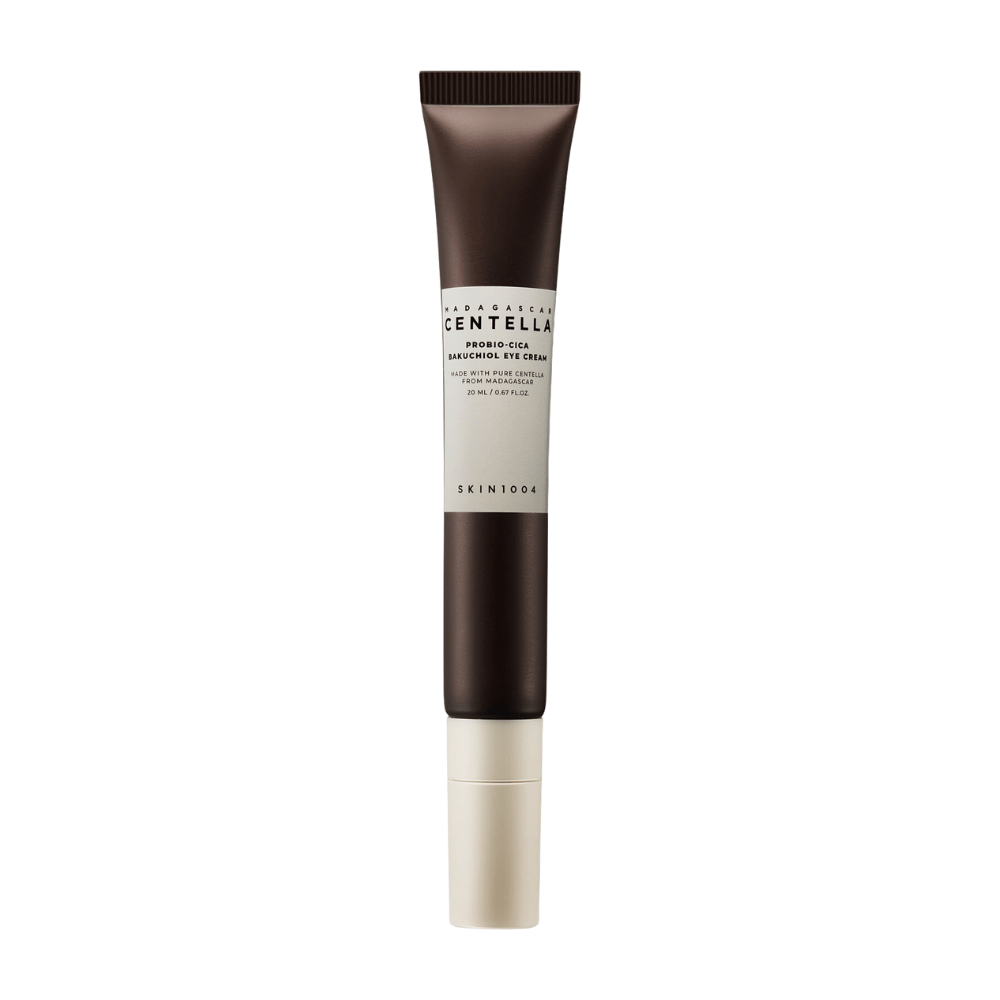 Un tubetto di "Madagascar Centella Probio-Cica Bakuchiol Eye Cream" da SKIN1004. Il prodotto è progettato per l'area degli occhi e contiene ingredienti come centella del Madagascar e bakuchiol, noti per le loro proprietà curative e idratanti per la pelle. Il tubetto è elegante con un colore marrone scuro che sfuma nel bianco.