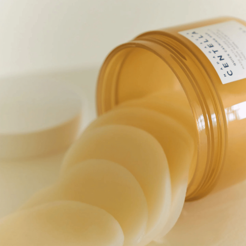 Barattolo aperto con SKIN1004 Madagascar Centella Quick Calming Pad – si vedono diversi dischetti rotondi in un liquido giallo chiaro, il barattolo è color ambra con etichetta bianca.
