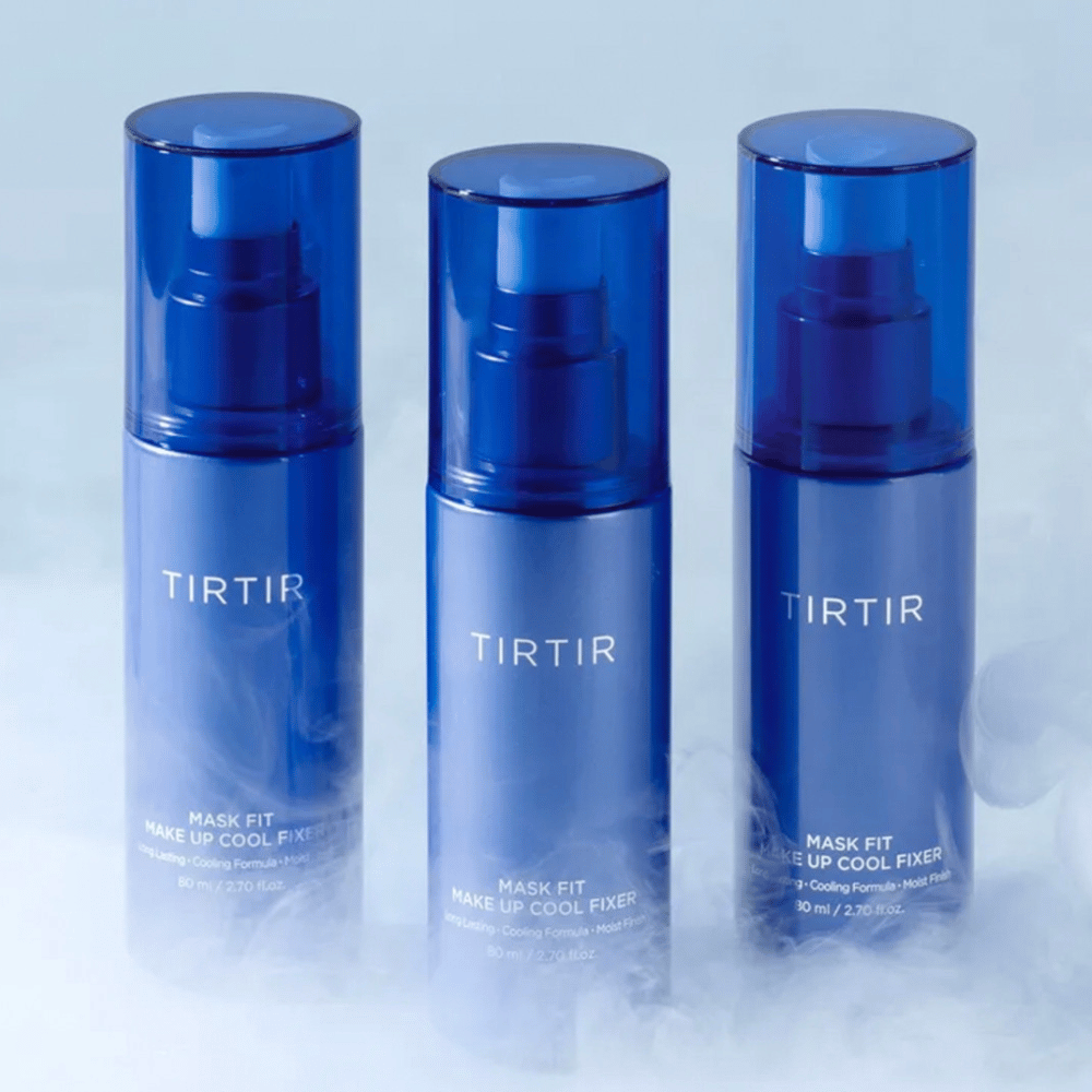 Tre flaconi spray blu con "TIRTIR Mask Fit Make Up Cool Fixer" sull'etichetta. Ogni flacone contiene 80 ml (2,70 fl. oz.) ed è progettato per offrire una sensazione rinfrescante e un trucco duraturo. I flaconi sono posizionati su uno sfondo chiaro con nebbia per creare un'atmosfera di freschezza.