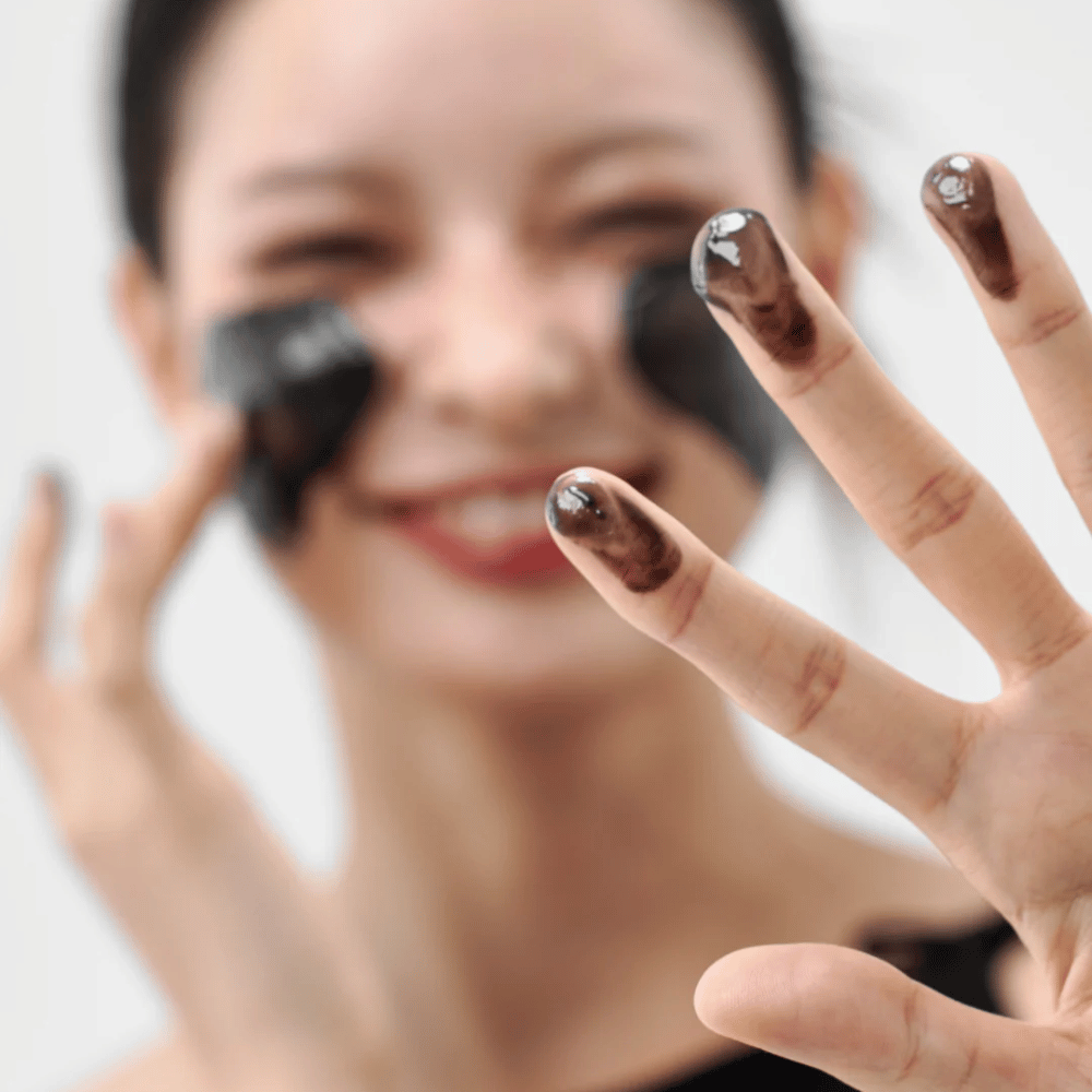 Modello applica Come Midnight Soothing Cleansing Balm sulla pelle. Balsamo detergente cremoso che pulisce in profondità e lascia la pelle morbida ed equilibrata.