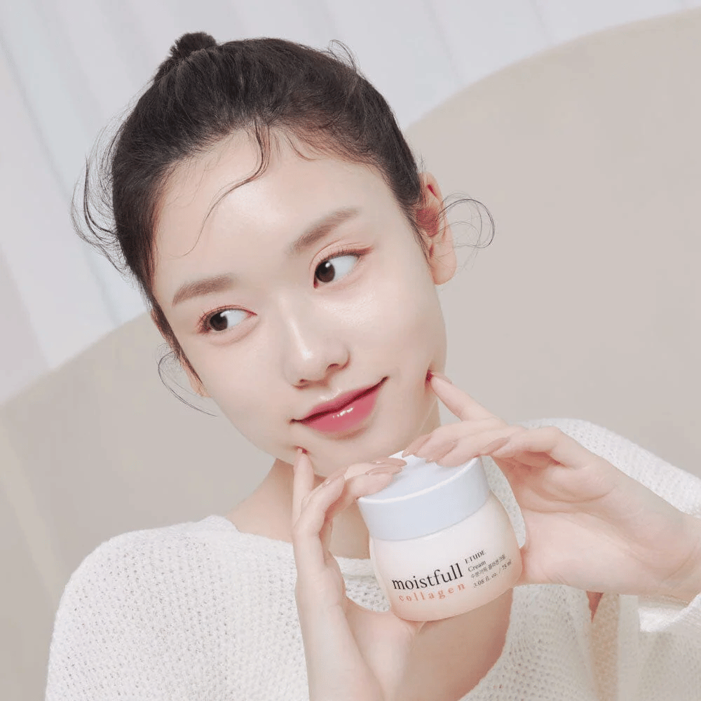 Donna tiene un barattolo "Moistfull Collagen Cream", maglietta bianca, sorridente.