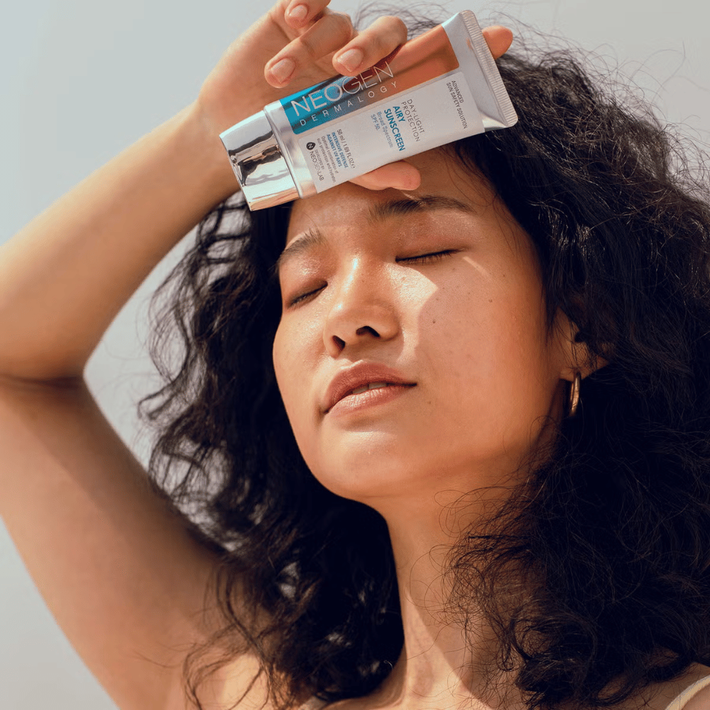 Neogen Dermalogy Day-Light Protection Airy Sunscreen SPF50 50ml – crema solare leggera con protezione UV a spettro ampio, mostrata in uso alla luce solare.