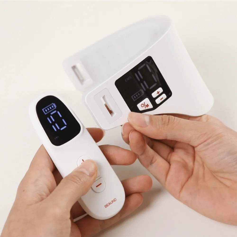 Beaund Neckcera è mostrato insieme al telecomando incluso. L'immagine dimostra il controllo wireless e il display digitale in cui intensità e funzioni possono essere regolate.