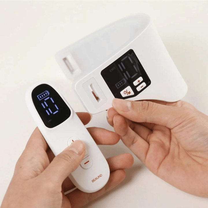 Beaund Neckcera è mostrato insieme al telecomando incluso. L'immagine dimostra il controllo wireless e il display digitale in cui intensità e funzioni possono essere regolate.