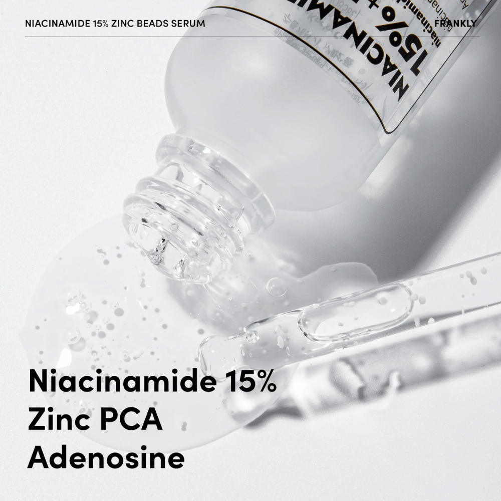 Primo piano di FRANKLY Niacinamide 15% + Zinc Beads Serum versato. Il testo mostra gli ingredienti: Niacinamide 15%, Zinc PCA e Adenosina.