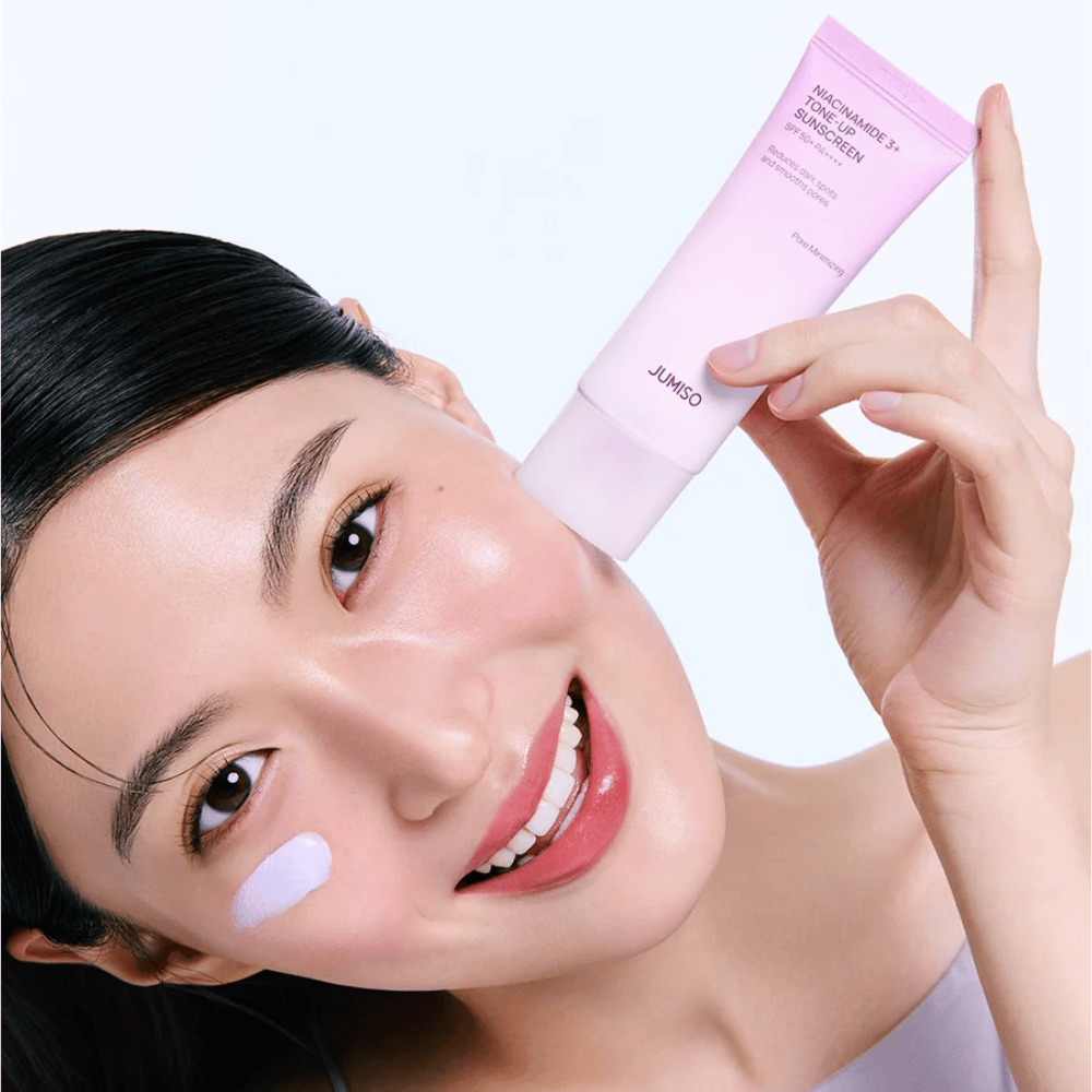 La modella applica JUMISO Niacinamide 3+ Tone-Up Sunscreen SPF50+ PA++++ per protezione UV, incarnato più uniforme e luminosità naturale.