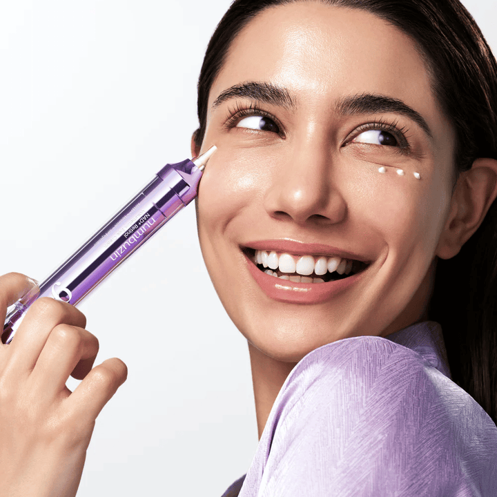 Modello che applica No.9 NAD+ Retinol Volumetox Eye Cream intorno agli occhi con un applicatore di precisione, per un trattamento mirato contro occhiaie e linee sottili.