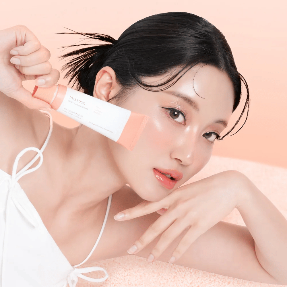 Persona con pelle radiosa tiene Mixsoon PDRN Collagen Cream vicino alla guancia. La crema idrata, rafforza l'elasticità e dona un bagliore sano.