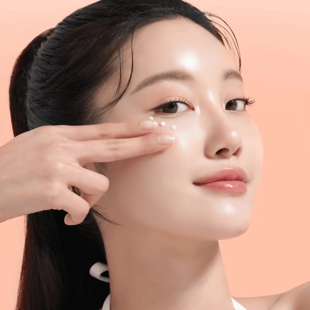 Una persona applica Mixsoon PDRN Collagen Eye Serum sotto gli occhi. Il siero illumina, riduce il gonfiore e rafforza la compattezza della pelle.