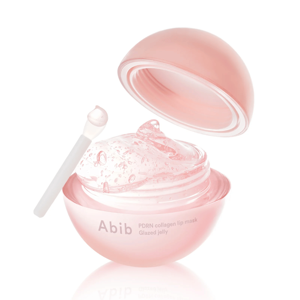 Barattolo rotondo rosa con Abib PDRN Collagen Lip Mask Glazed Jelly, aperto con il coperchio inclinato all'indietro. Gel trasparente con bolle d'aria visibile nel barattolo insieme a una piccola spatola.