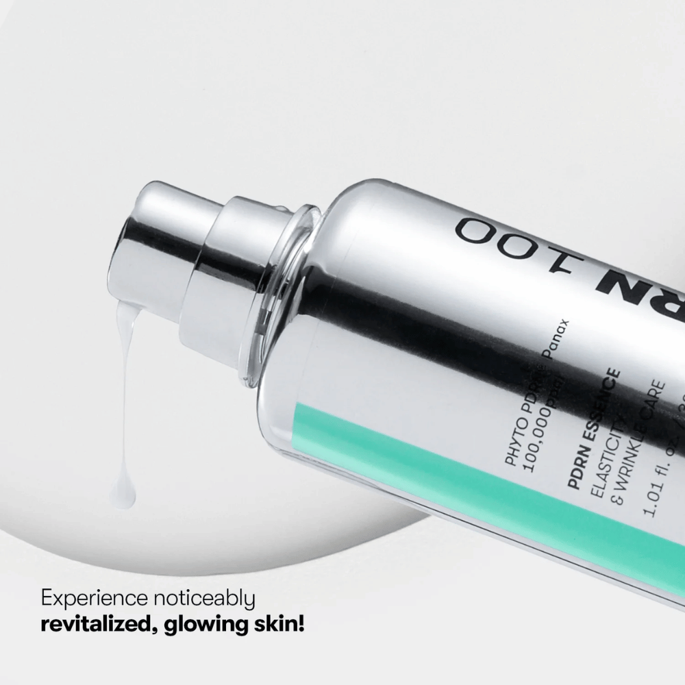 Primo piano di un flacone con pompa argentato con VT PDRN Essence 100. Un'essenza bianca scorre dall'erogatore, e il testo sull'immagine recita: "Experience noticeably revitalized, glowing skin!"