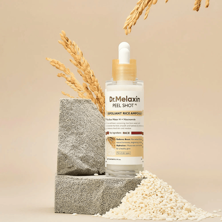 Dr.Melaxin Peel Shot Exfoliant Rice Ampoule in piedi con riso e blocchi di pietra, fiala esfoliante coreana con estratto di riso e niacinamide per una pelle più chiara e morbida.