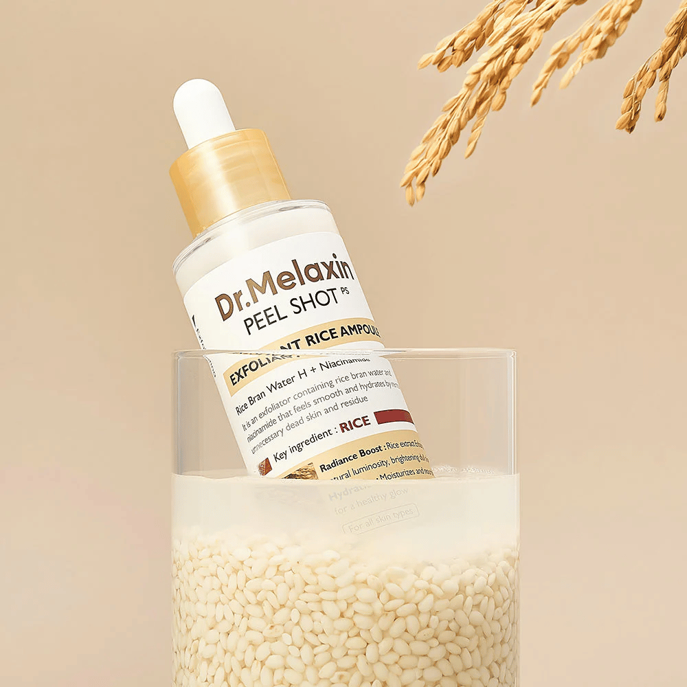 Dr.Melaxin Peel Shot Exfoliant Rice Ampoule posizionata in un bicchiere con riso, illustra le proprietà illuminanti e idratanti dell'estratto di riso nella cura della pelle coreana.