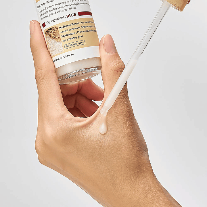Immagine ravvicinata di Dr.Melaxin Peel Shot Rice Ampoule applicata con pipetta sulla mano, fiala esfoliante leggera che si assorbe rapidamente e dona pelle idratata e liscia.