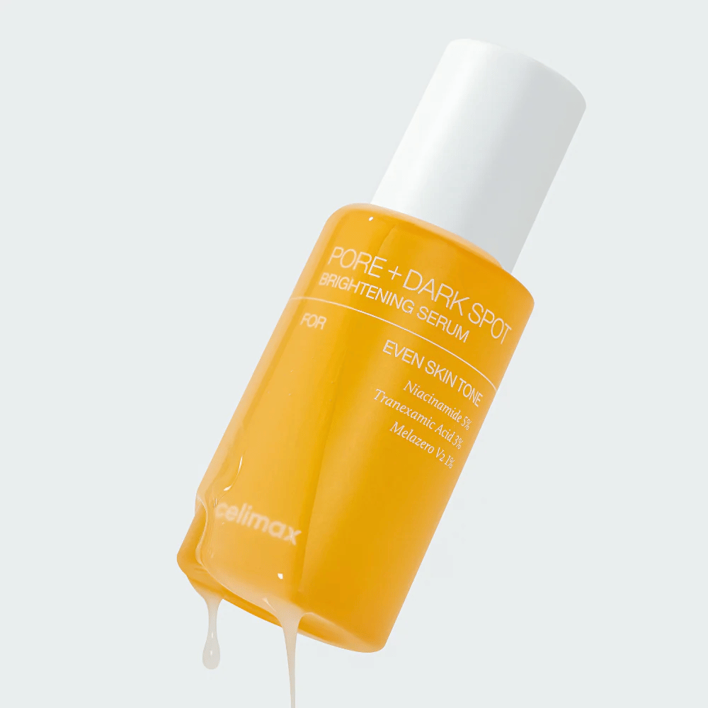 Celimax Pore + Dark Spot Brightening Serum in una bottiglia gialla con tappo bianco, gocce di siero scorrono lungo la bottiglia.