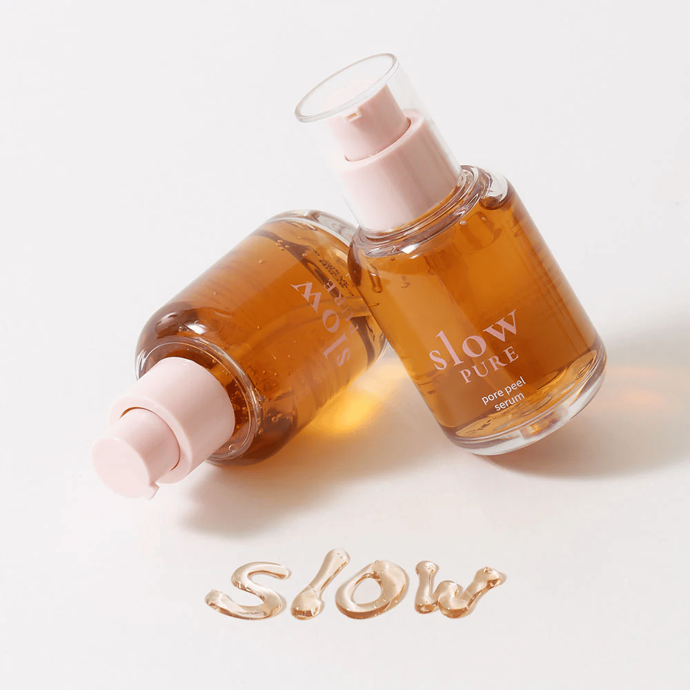 Två flaskor Slow Pure Pore Peel Serum med pump, text skriven i serum på ytan: "Slow".