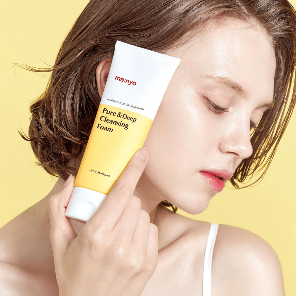 Donna con pelle fresca e idratata tiene Ma:nyo Pure & Deep Cleansing Foam – detergente delicato detergente viso che dona luminosità ed equilibrio con ingredienti naturali.