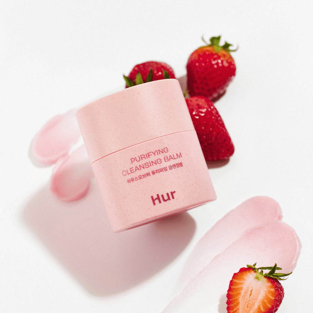 Come Purifying Cleansing Balm posizionato con fragole fresche. Balsamo detergente che dona una pelle liscia e adatto per l'uso quotidiano detergente viso.