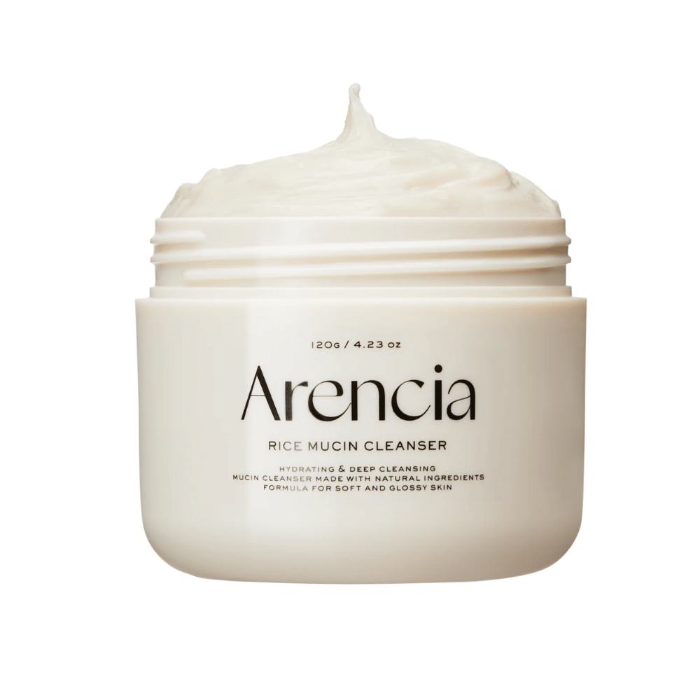 Immagine del prodotto su Arencia Rice Mucin Cleanser in un barattolo bianco con una texture cremosa e montata che sporge dall'apertura. Il testo sulla confezione enfatizza l'idratazione e la pulizia profonda.