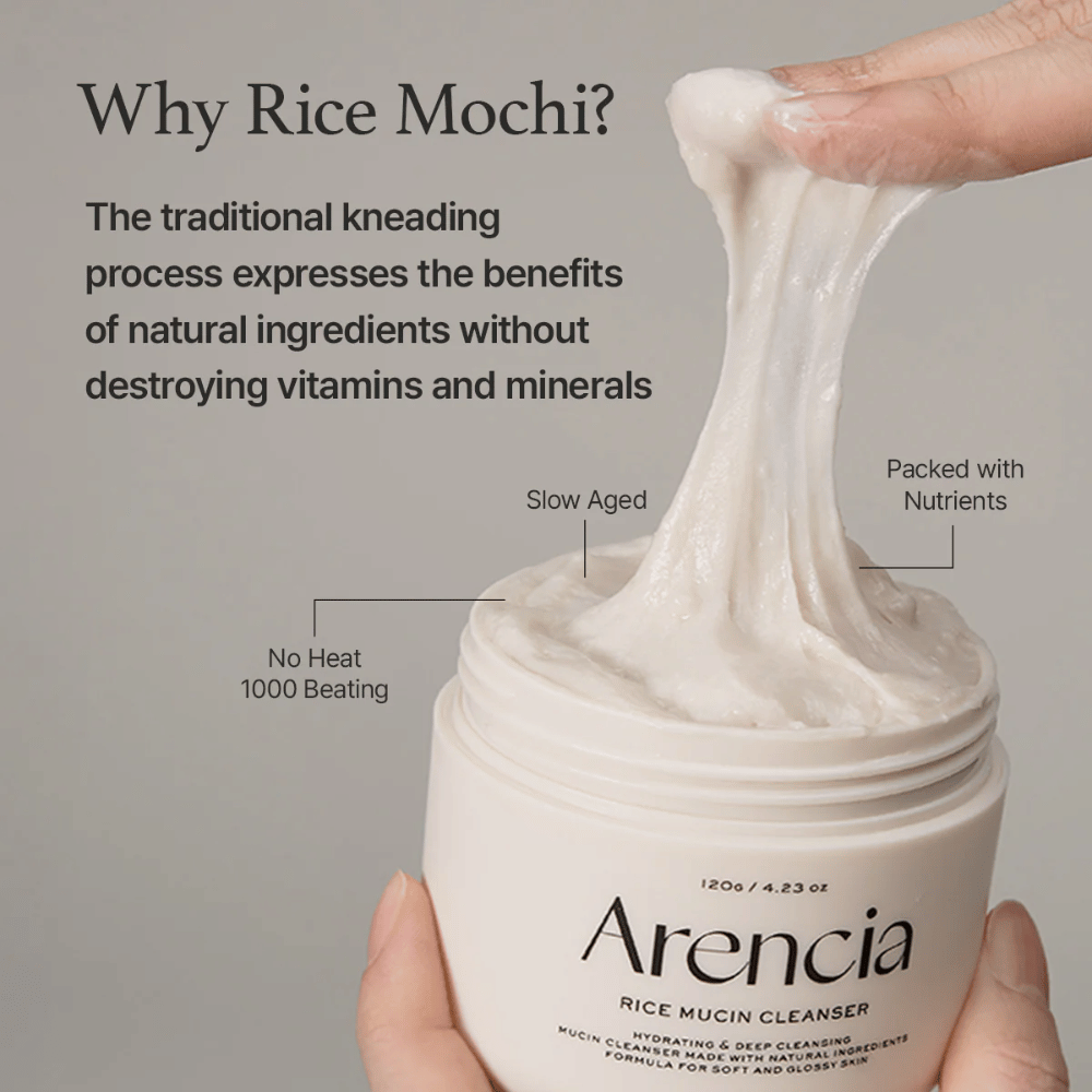 Mano che solleva una crema detergente bianca ed elastica da un barattolo etichettato "Arencia Rice Mucin Cleanser". Il testo descrive la tradizionale lavorazione che conserva i nutrienti senza distruggere vitamine e minerali.