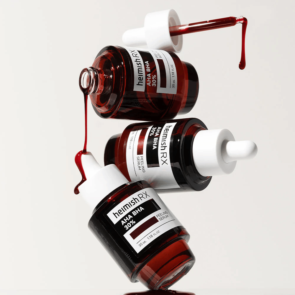Tre bottiglie di Heimish RX AHA BHA 30% Peeling Serum in una composizione dinamica, con siero rosso che gocciola dalle pipette.