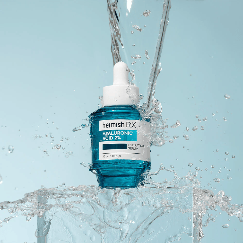 Heimish RX Siero idratante all'acido ialuronico 2% posizionato su una superficie simile al ghiaccio con acqua che schizza intorno, simbolizzando idratazione intensa e freschezza.