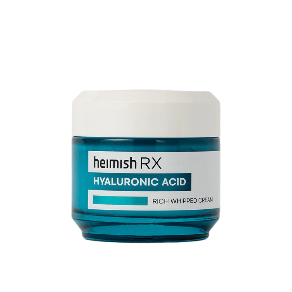 Heimish RX Hyaluronic Acid Rich Whipped Cream in un elegante barattolo di vetro blu con coperchio bianco. Una crema viso nutriente con acido ialuronico per un'idratazione intensa e una pelle morbida e piena.