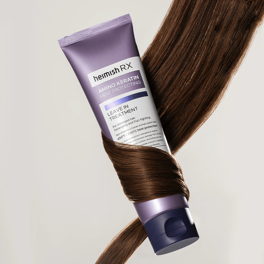 Heimish RX Amino Keratin Leave-In Treatment – trattamento per capelli nutriente e protettivo dal calore circondato da capelli lucenti, simboleggia l'effetto rinforzante e idratante per capelli danneggiati.