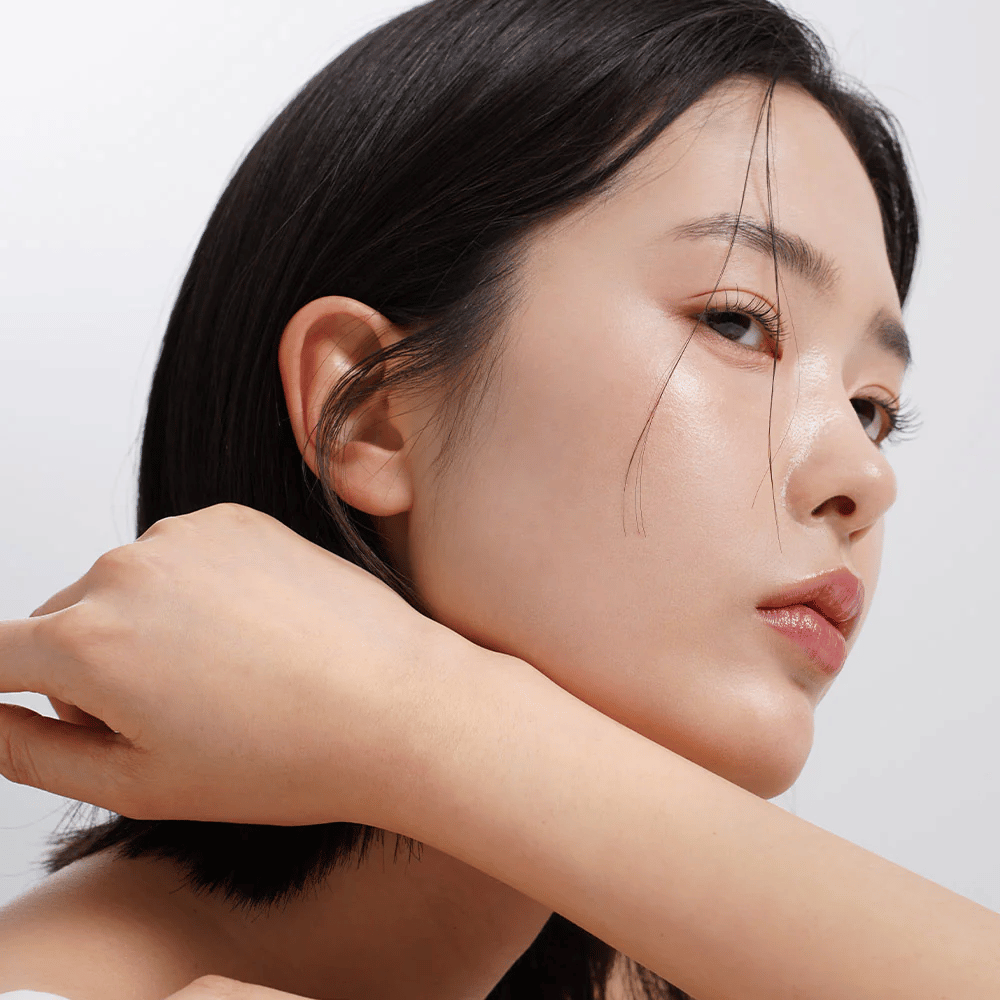 Primo piano di una donna con pelle uniforme, radiosa e con luminosità naturale. Perfetta ispirazione per la cura della pelle per una pelle sana e idratata.