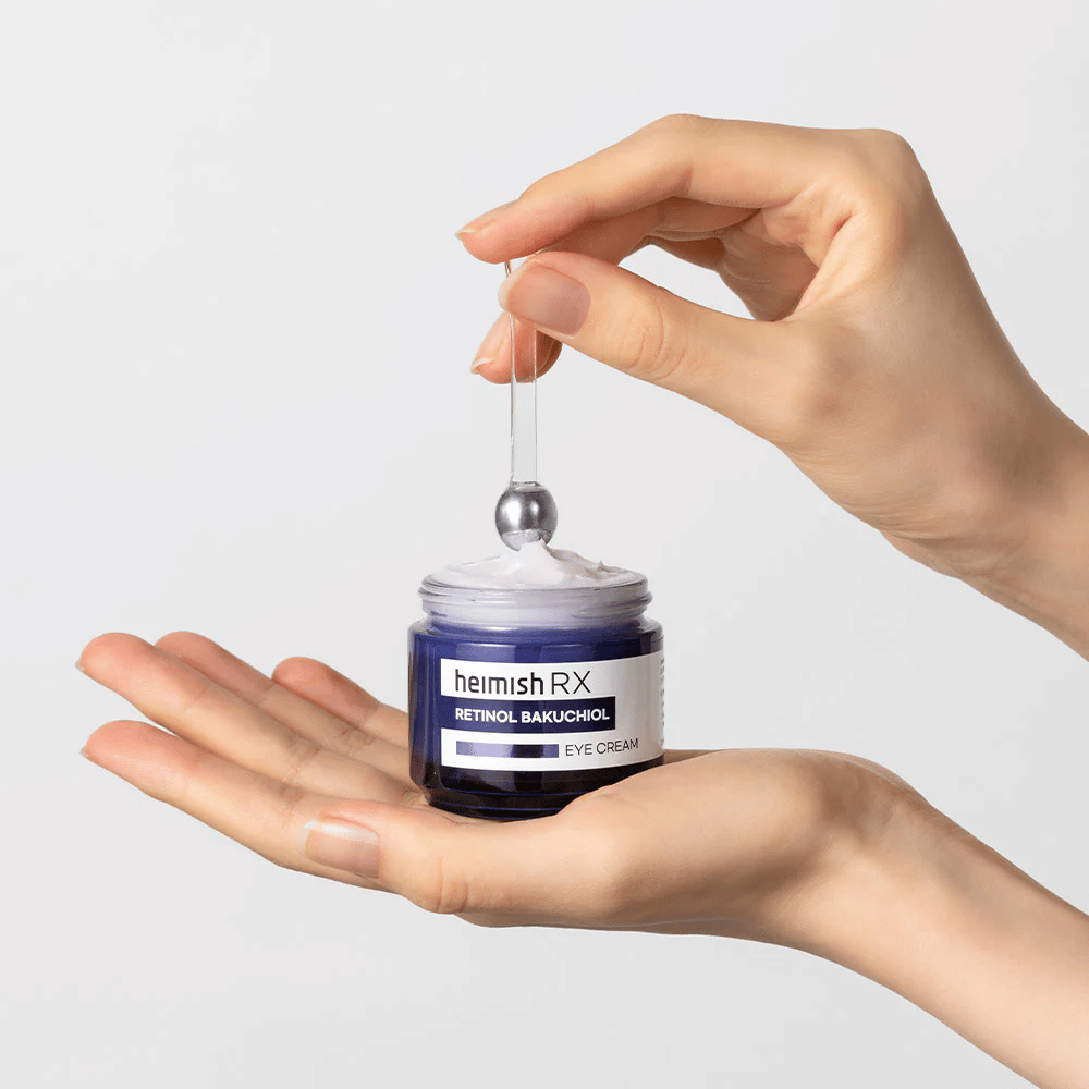 Heimish RX Retinol Bakuchiol Eye Cream in un elegante barattolo blu, sollevato con un applicatore in metallo. Un crema contorno occhi con retinolo e bakuchiol per ridurre le linee sottili e dare una pelle più soda.