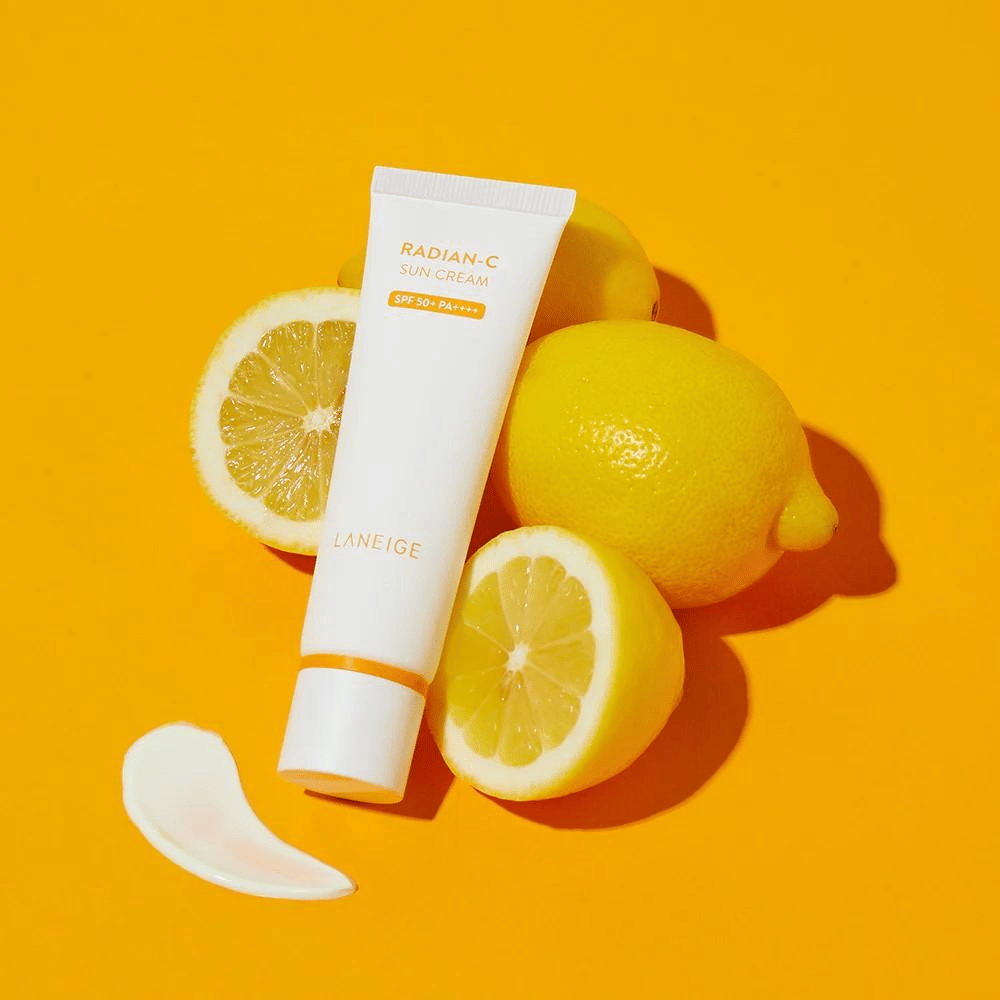 LANEIGE Radian-C Sun Cream SPF 50+ PA++++ con limoni e una goccia di crema solare su uno sfondo giallo vivace.