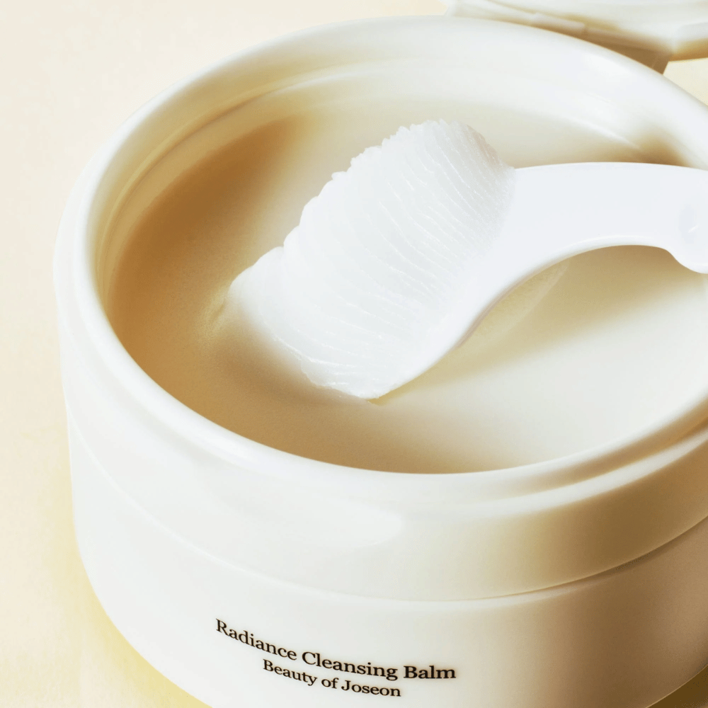 Primo piano su Beauty of Joseon Radiance Cleansing Balm in barattolo con spatola – balsamo setoso che pulisce e idrata.