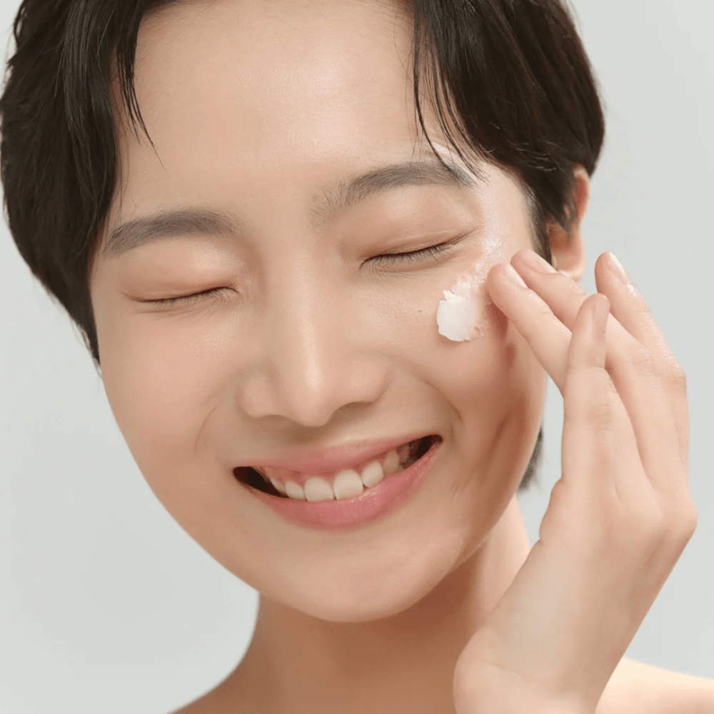 Modello con pelle luminosa applica Beauty of Joseon Radiance Cleansing Balm – balsamo struccante coreano che dissolve trucco e impurità.