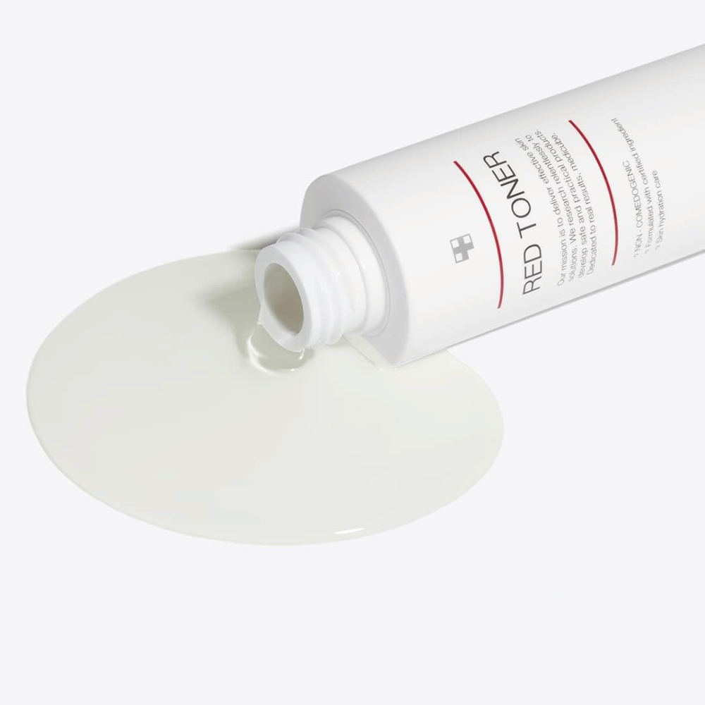 Bottiglia aperta con medicube Red Toner versata su una superficie bianca – mostra la consistenza leggera e fluida del prodotto.