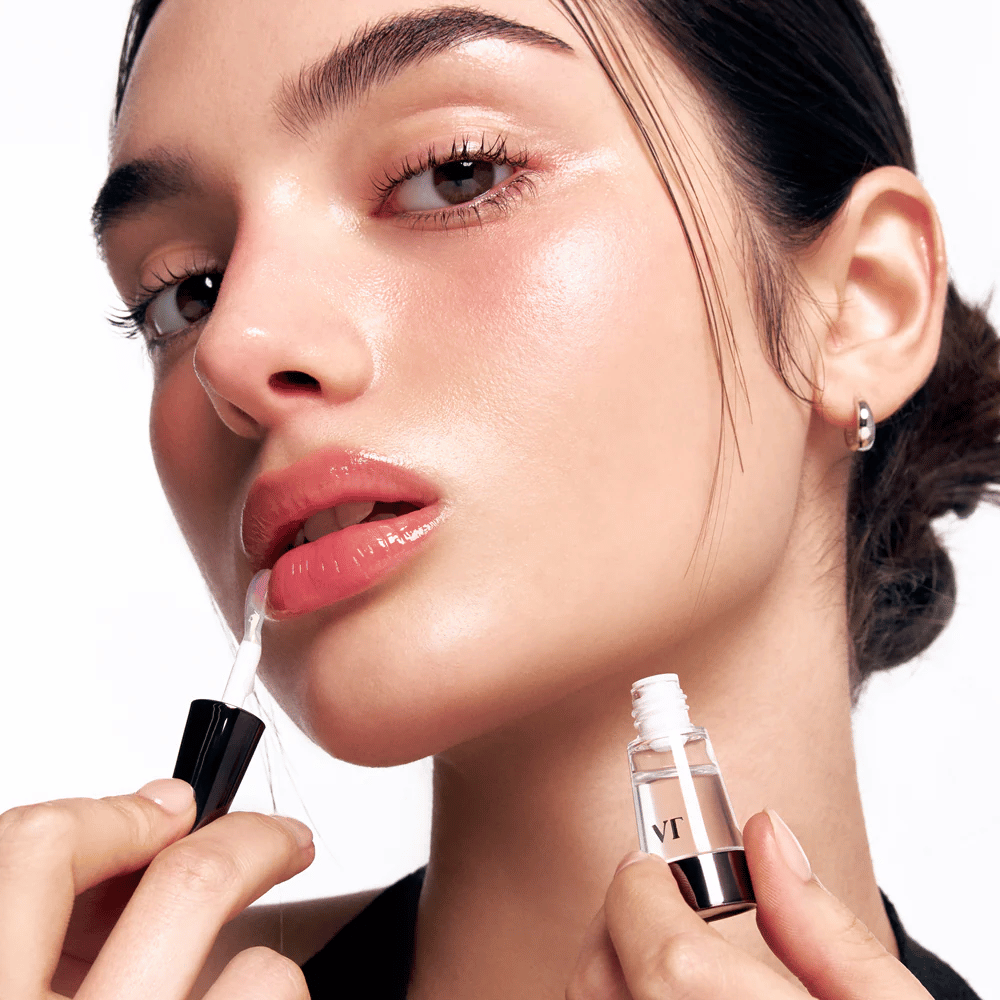 Modella applica VT Cosmetics Reedle Shot Lip Plumper Beginner sulle labbra per un effetto rimpolpante naturale, lucentezza e idratazione con un leggero effetto pizzicante.