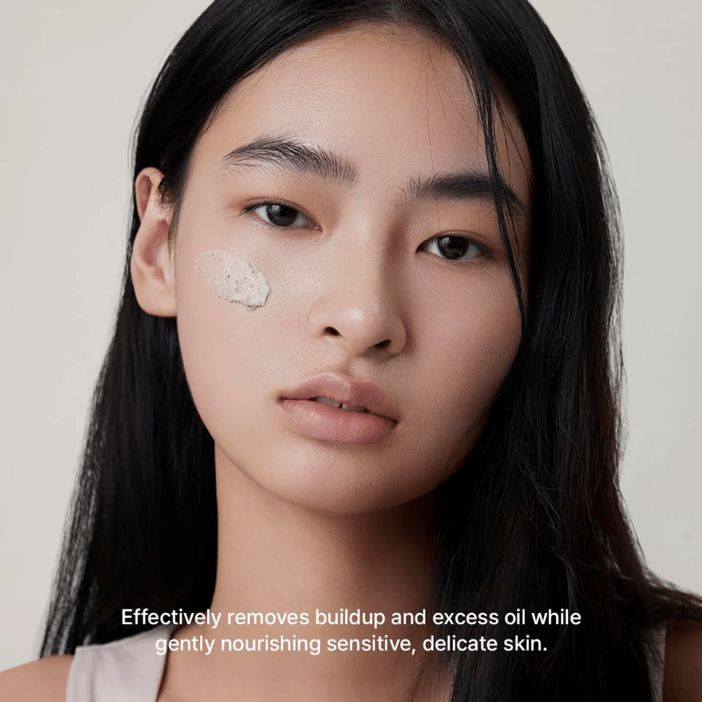 Modello con Arencia Rice + LHA Pore Control Rice Cake Cleanser applicato sulla guancia, delicato detergente viso che rimuove efficacemente sporco e sebo in eccesso senza seccare la pelle.