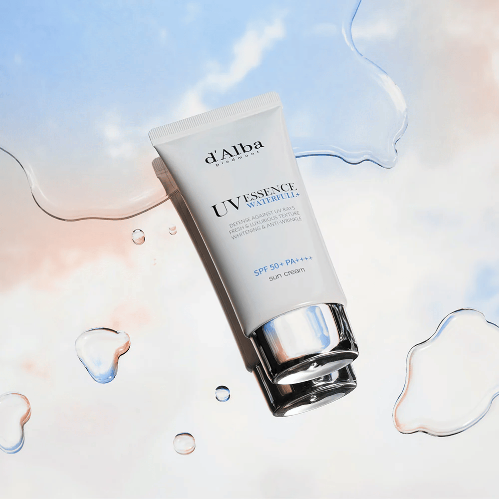 Immagine del prodotto su d'Alba UV Essence Waterfull+ Sun Cream con SPF 50+ PA++++, posizionata su uno sfondo con schizzi d'acqua e cielo blu-rosa – simboleggia una protezione solare leggera e idratante.