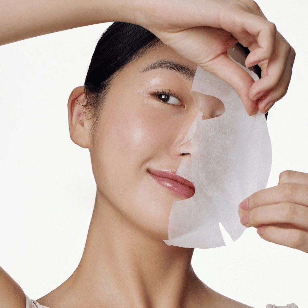Questa immagine mostra una persona che utilizza un maschera viso, specificamente "Galactomyces Glutathione Daily Mask" da Some By Mi. La maschera illumina la pelle e dona una luminosità radiosa mentre si prende cura e idrata profondamente la pelle, grazie a ingredienti come glutatione e vitamina C.