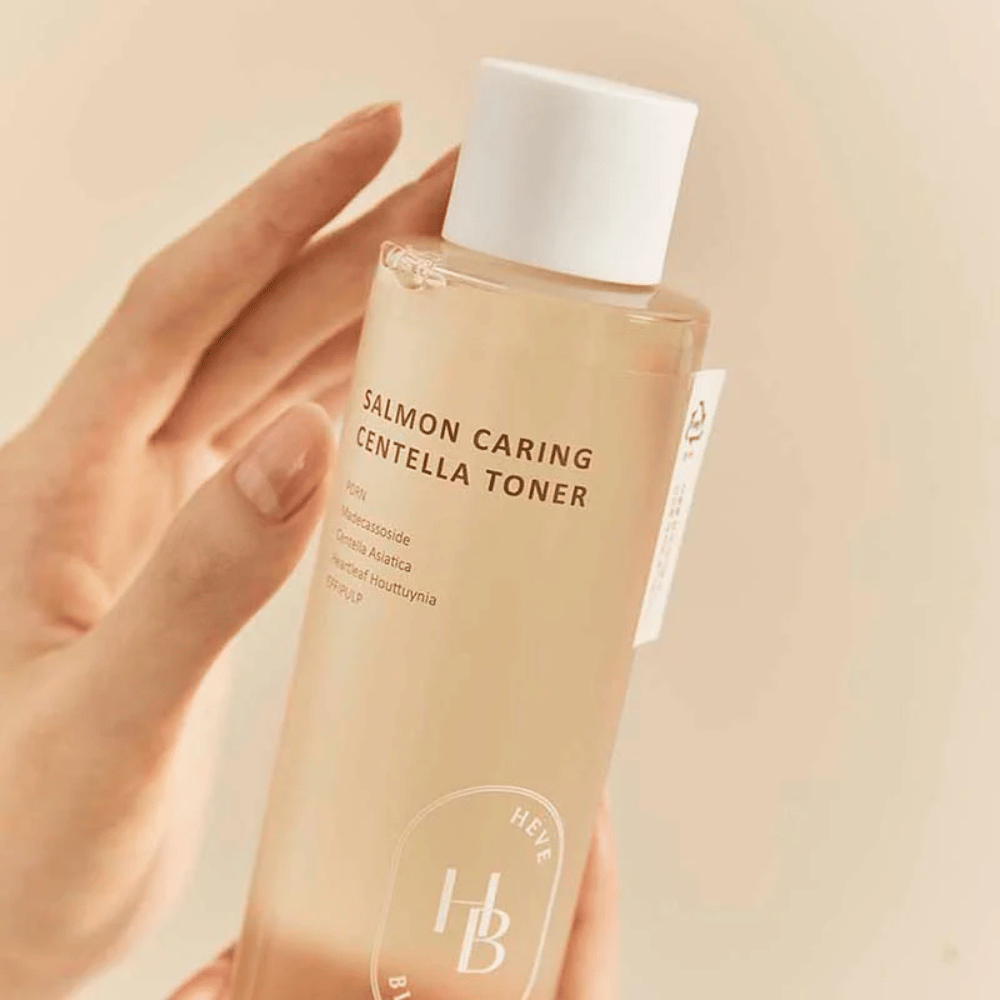 Primo piano di Salmon Caring Centella Toner in mano – tonico lenitivo con PDRN ed estratti vegetali che aiutano a rafforzare la pelle e ridurre la sensazione di irritazione.