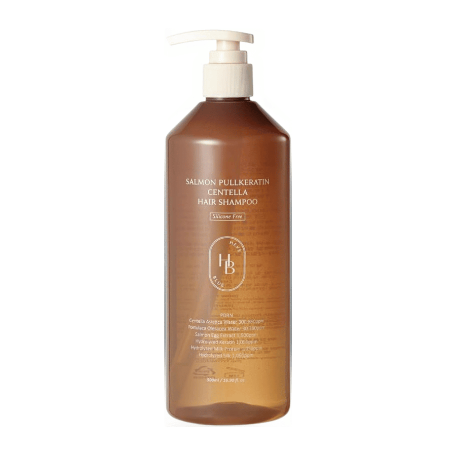 Heveblue Salmon Pullkeratin Centella Hair Shampoo in flacone dispenser trasparente marrone su sfondo chiaro. Shampoo con centella, estratto di salmone e cheratina che aiuta a detergere e prendersi cura dei capelli.
