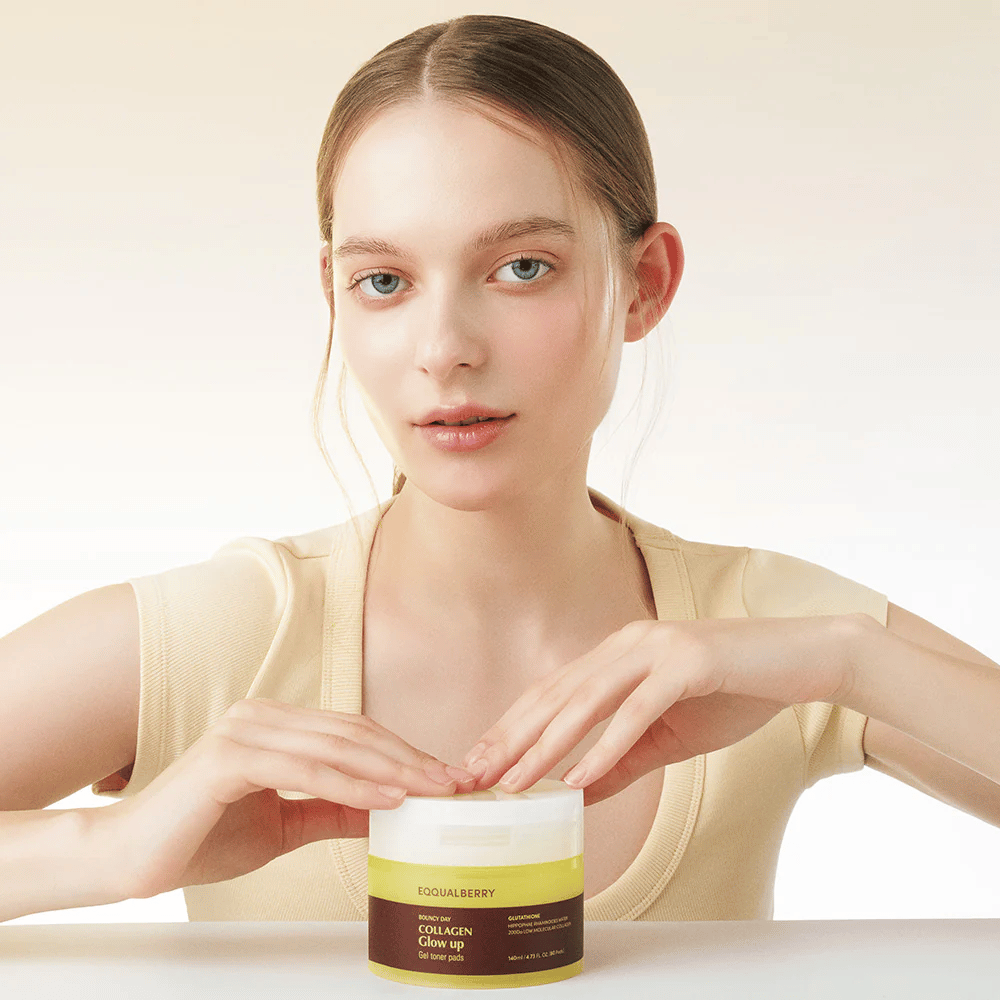 Modello che tiene in mano Bouncy Day Collagen Glow up Gel Toner Pads, che idrata e dona un bel bagliore con collagene a basso peso molecolare e glutatione.