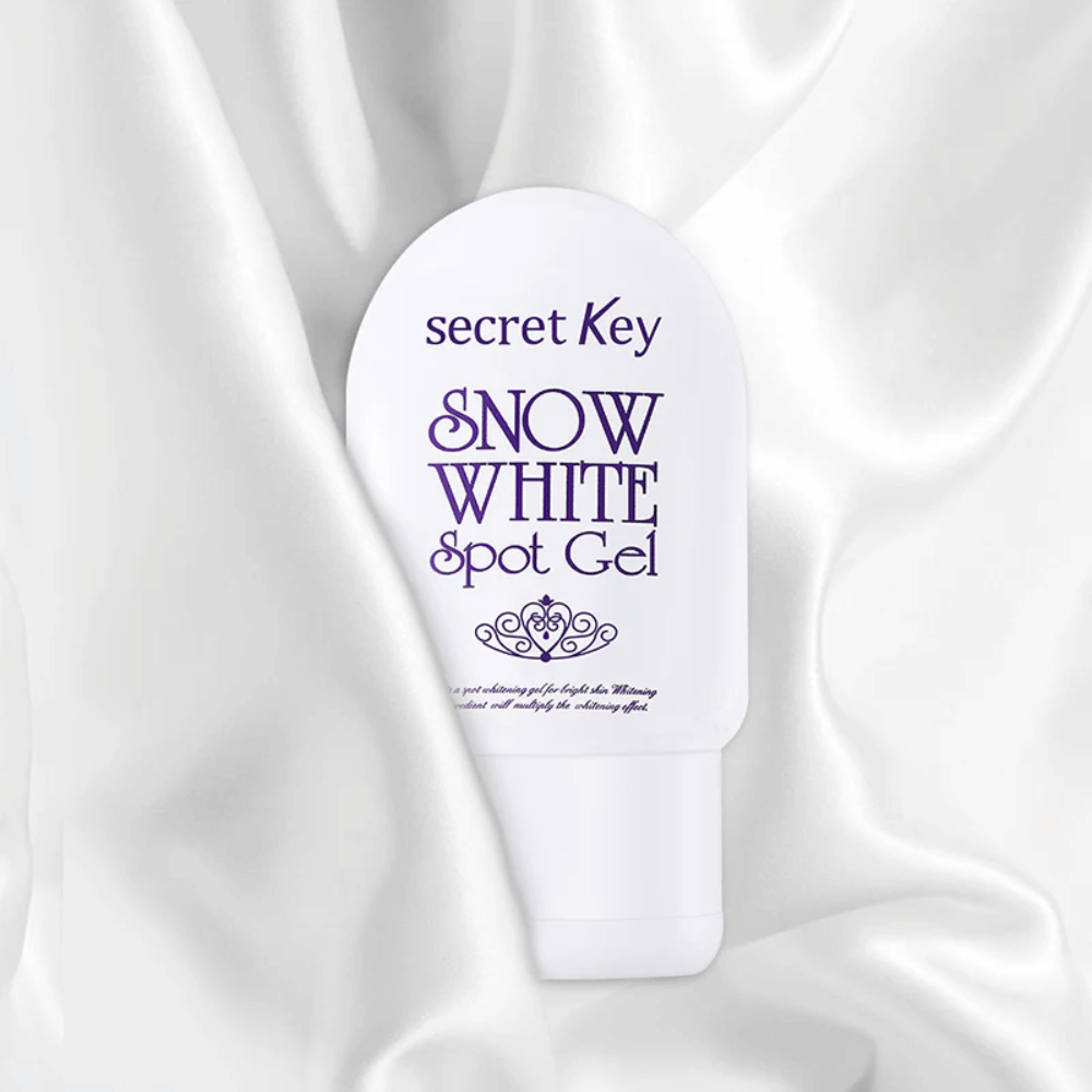 Secret Key Snow White Spot Gel posizionato su sfondo di tessuto simile a seta bianca.